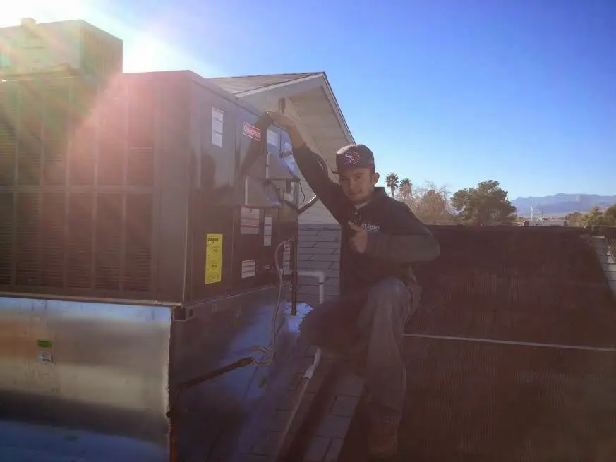 HVAC technician performing HVAC Inspection on a rooftop unit in Plano